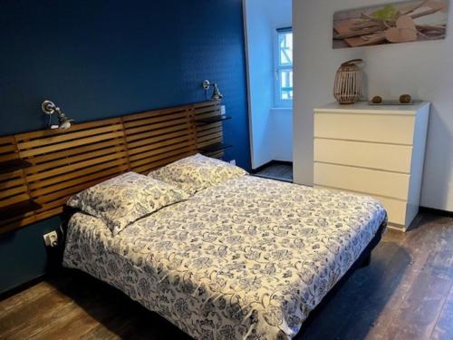 科尔马Gîte Grand'Rue "Climatisé"的一间卧室配有一张带木制床头板的床和梳妆台。
