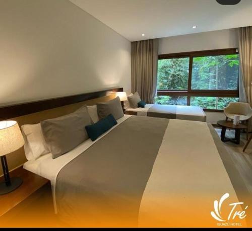 伊瓜苏港Hotel Tré Iguazú的卧室设有一张大床,卧室设有大窗户