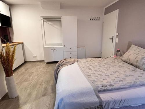 新伊森堡Gemütlich mitten in Neu-Isenburg的一间卧室配有一张大床和一个白色的橱柜