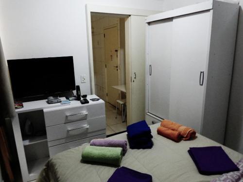 里约热内卢森塔纳坦姆波拉达 - 科帕卡巴纳圣母公寓的一间卧室配有带枕头的床铺和电视。