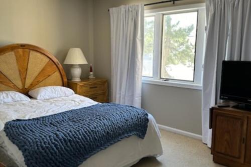 希塞德高地Sea Breeze Beach View的一间卧室设有一张床、一个窗口和一台电视