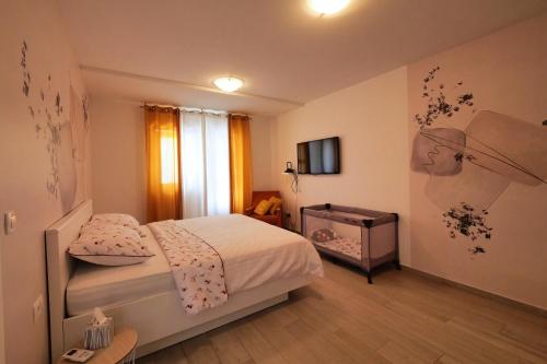 MočićiDubrovnik Airport Apartment Pascal的一间小卧室,配有一张床和电视