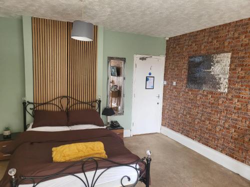 LitherlandJubilee pub的一间卧室设有一张床和砖墙