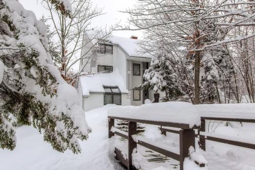 基灵顿Sunrise Mountain Village的雪覆盖的院子,围栏和房子