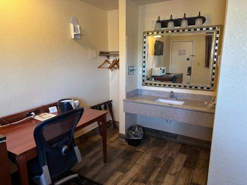 林垦Comfort stay inn的一间带水槽的浴室和一张带镜子的书桌