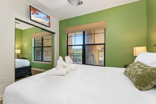 达文波特Sunny Retreat Close to Disney Pool Bella Piazza的卧室设有白色的床和绿色的墙壁