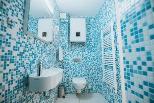 诺瓦利娅Basilica hotel - made for fun!的蓝色瓷砖浴室设有水槽和卫生间