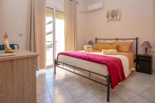 罗德镇Rodini Sun Apartment的一间卧室配有一张床铺,床上铺有红色毯子