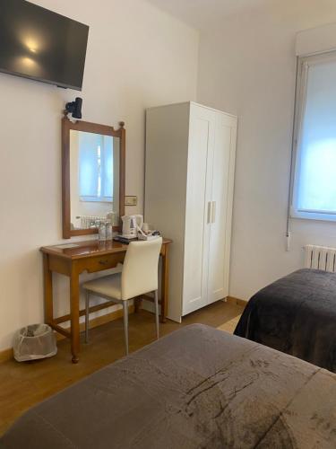 巴约讷Hotel Carabela La Pinta的一间卧室配有书桌、一张床和镜子