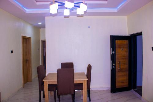 伊巴丹ODTC Homes and Apartments的一间带木桌和椅子的用餐室