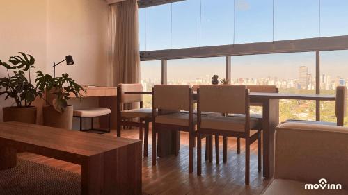 圣保罗White 2880 - Pinheiros的一间带桌椅和大窗户的用餐室