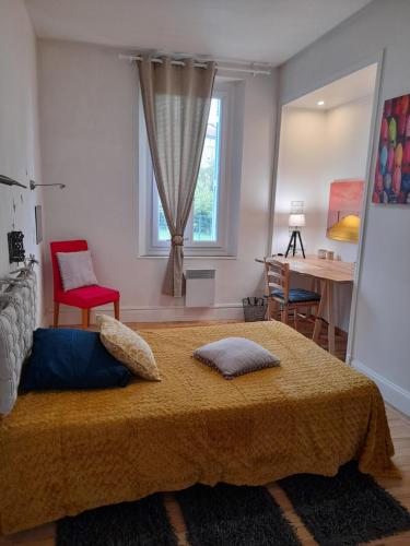 帕米耶Pamiers gare - 2 Appartements à louer ou Chambre parentale indépendante的一间卧室配有一张床、一张桌子和一个窗户。