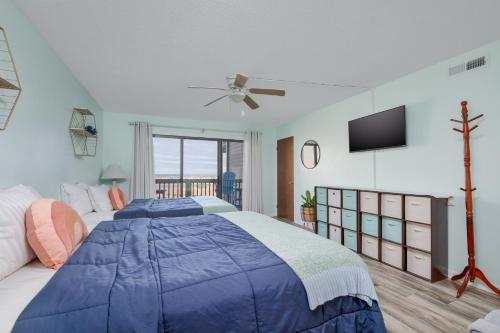达克2971 - Seabbatical by Resort Realty的一间卧室配有蓝色的床和一台平面电视