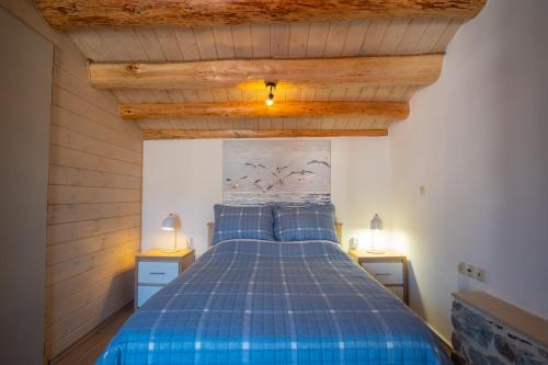 库卡里A window to the Aegean的一间卧室配有蓝色的床和2个床头柜