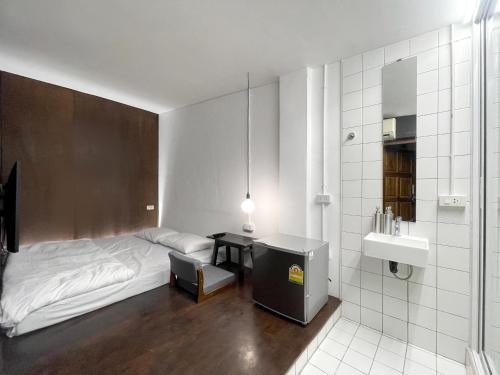 邦拉Chatel BKK的一间卧室配有一张床,浴室设有水槽