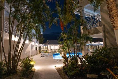 基督教堂市South Point Hotel的夜间带游泳池和棕榈树的度假村