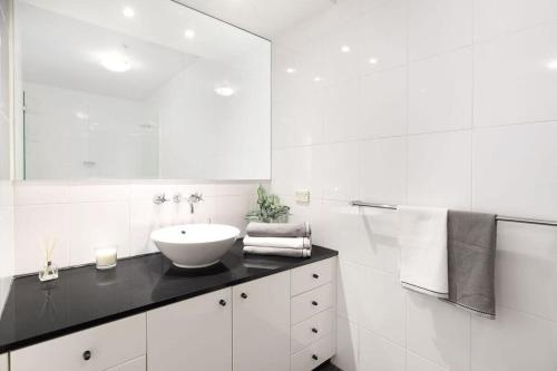 悉尼NEW! A Comfy & Stylish Apt Next to Darling Harbour的白色的浴室设有水槽和镜子