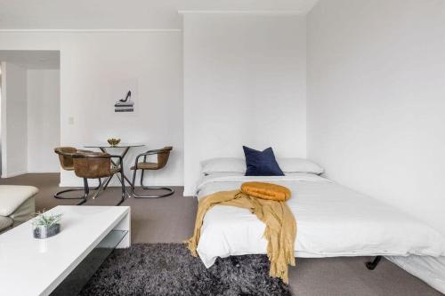 悉尼NEW! A Comfy & Stylish Apt Next to Darling Harbour的白色卧室配有床和桌子