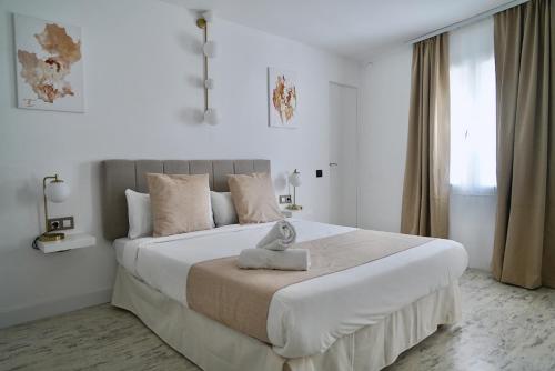 锡切斯Aldara Sitges的一间白色卧室,房间内设有一张大床