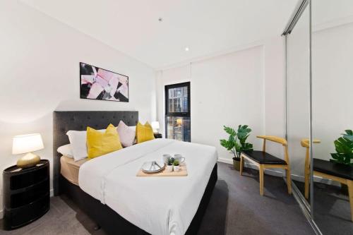 墨尔本A Modern & Spacious 2BR Apt City Views Southbank的一间卧室配有一张带黄色枕头的大床