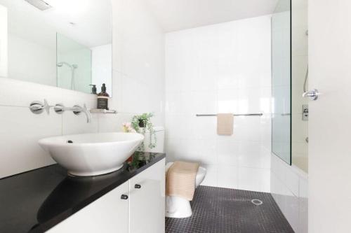 悉尼A Comfy 2BR Apt Harbour View FREE Parking的白色的浴室设有水槽和淋浴。
