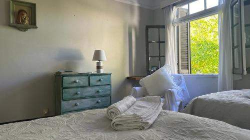 蒙得维的亚Casona de Estilo Inglés的一间卧室配有一张床、一个梳妆台和一扇窗户。
