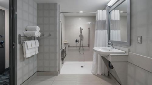 温尼伯机场西温尼伯假日酒店 的带淋浴和盥洗盆的白色浴室