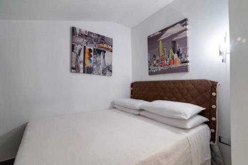 加拉蒂纳Salento Home的卧室内的一张床铺,墙上有两张照片