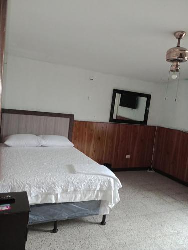 危地马拉Mundo Hostal的卧室配有一张床,墙上设有镜子