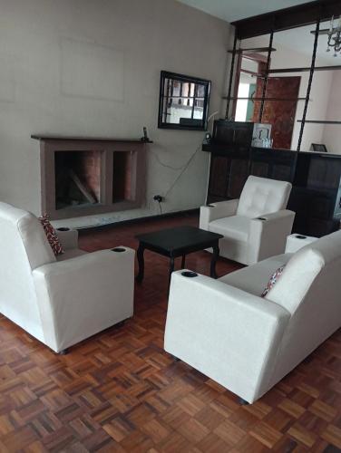危地马拉Mundo Hostal的客厅配有白色沙发和壁炉
