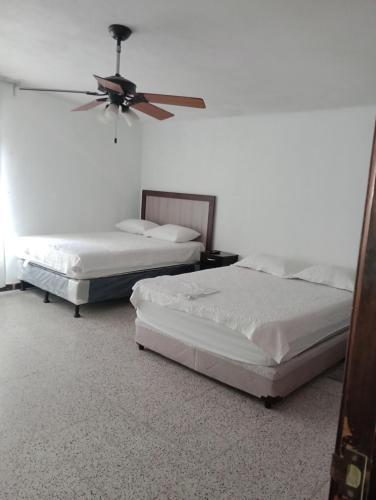 危地马拉Mundo Hostal的配有吊扇的客房内的两张床