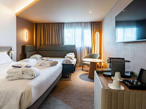 兰斯兰斯塔基诺富特酒店的酒店客房,配有两张带毛巾的床