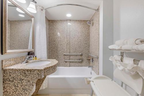 尤利贝斯特韦斯特Plus第一海岸套房酒店的白色的浴室设有浴缸和水槽。