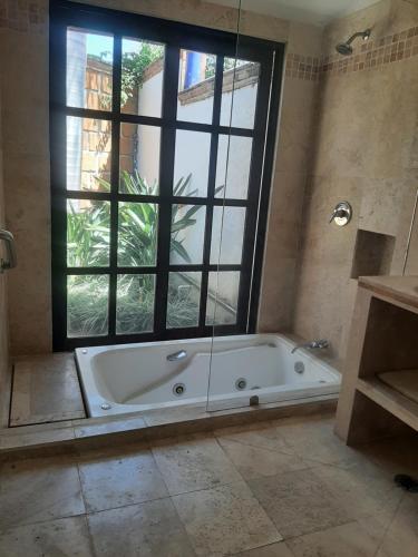 库埃纳瓦卡Quinta Edén Cuernavaca的带浴缸的浴室和大窗户