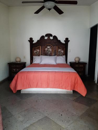 库埃纳瓦卡Quinta Edén Cuernavaca sala的一间卧室配有一张红色的床和吊扇