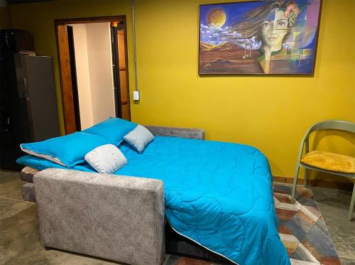 卡希卡Container convertido en acogedor apartamento的卧室配有一张床,墙上挂有绘画作品