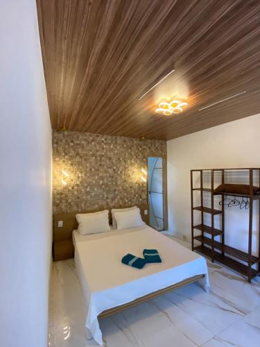 Praia de Palmas• Suíte Palmas • À Beira-Mar - Ilha Grande RJ®的卧室配有白色床和木制天花板