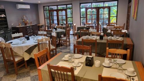 伊瓜苏港Hotel Cabañas del Leñador的用餐室设有桌椅和窗户。