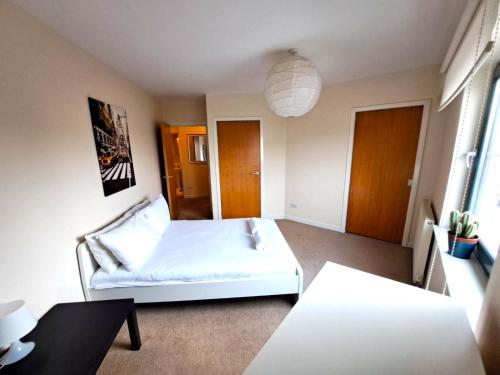 佩斯利Modern 2 Bed Apartment Close to Gla Airport & M8的卧室配有白色的床和桌子