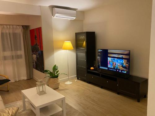 瓦伦西亚Apartamento centrico familiar en Valencia( Frente Estacion Ave ,Joaquin Sorolla)的客厅配有平面电视和桌子。