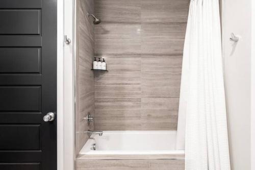 丹佛Denver suites rino arts loft - jz vacation rentals的带浴缸和淋浴帘的浴室