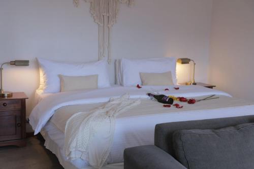 塔尔塔尔Cabañas Caleta Hueso的一间卧室配有一张白色大床,床上有鲜花