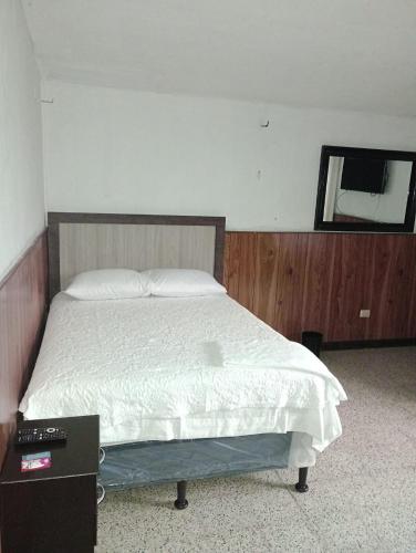 危地马拉MUNDO HOSTAL的卧室配有一张床,墙上设有镜子