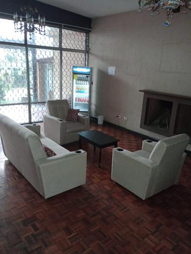 危地马拉MUNDO HOSTAL的客厅配有白色家具和壁炉
