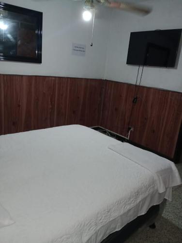 危地马拉MUNDO HOSTAL的卧室配有白色的床和平面电视。