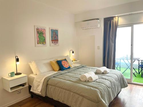 布宜诺斯艾利斯Alfonsina Hostel的一间卧室配有一张大床和毛巾