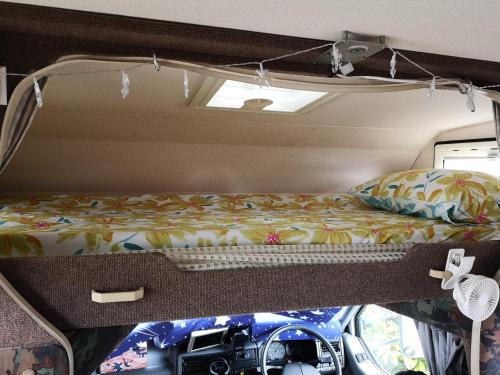 皇后镇Motorhome Experience的露营车后面的一张带摄像头的床铺