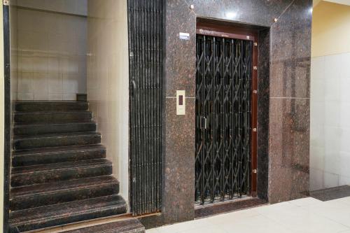 商沙巴69076 OYO Hotel Sweekar的大楼内带楼梯的金属门