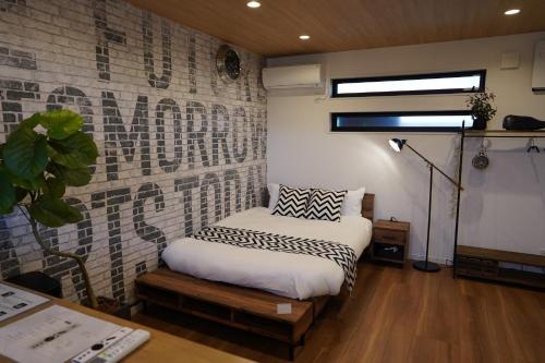 广岛RGH ISHIUCHI BASE02 - Vacation STAY 14828的一间卧室设有一张床和砖墙