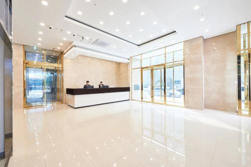 仁川市Gold Coast Hotel Incheon的大厅,有两个人坐在大楼的柜台上